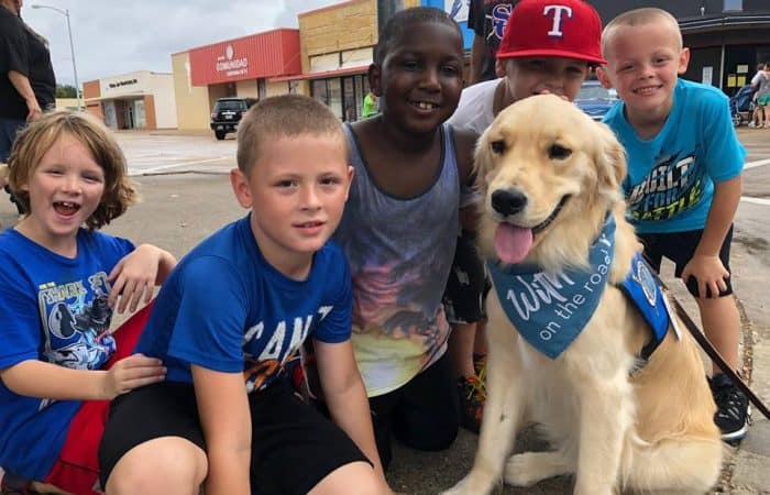 Triton the comfortdog posing for a phot with a group of young children