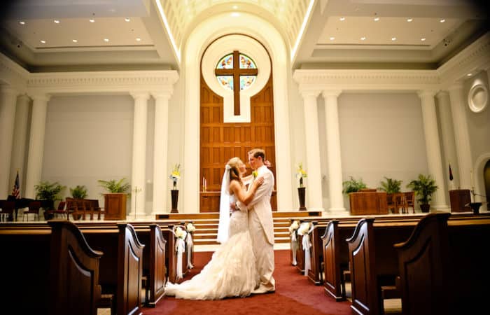 Just married couple embracing in front of altar