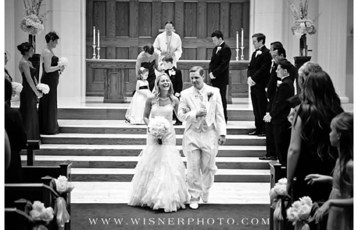 Black and white photo a just married couple walking down the aisle in Messiah church. Watermark of www.wisnerphoto.com